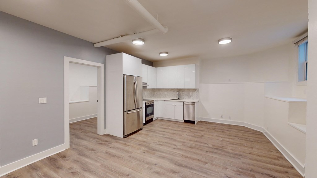 a kitchen with white cabinets and a stainless steel refrigerator