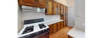 a kitchen with wooden cabinets and white counter tops and a stove top oven