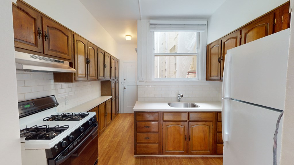a kitchen with white appliances and wooden cabinets