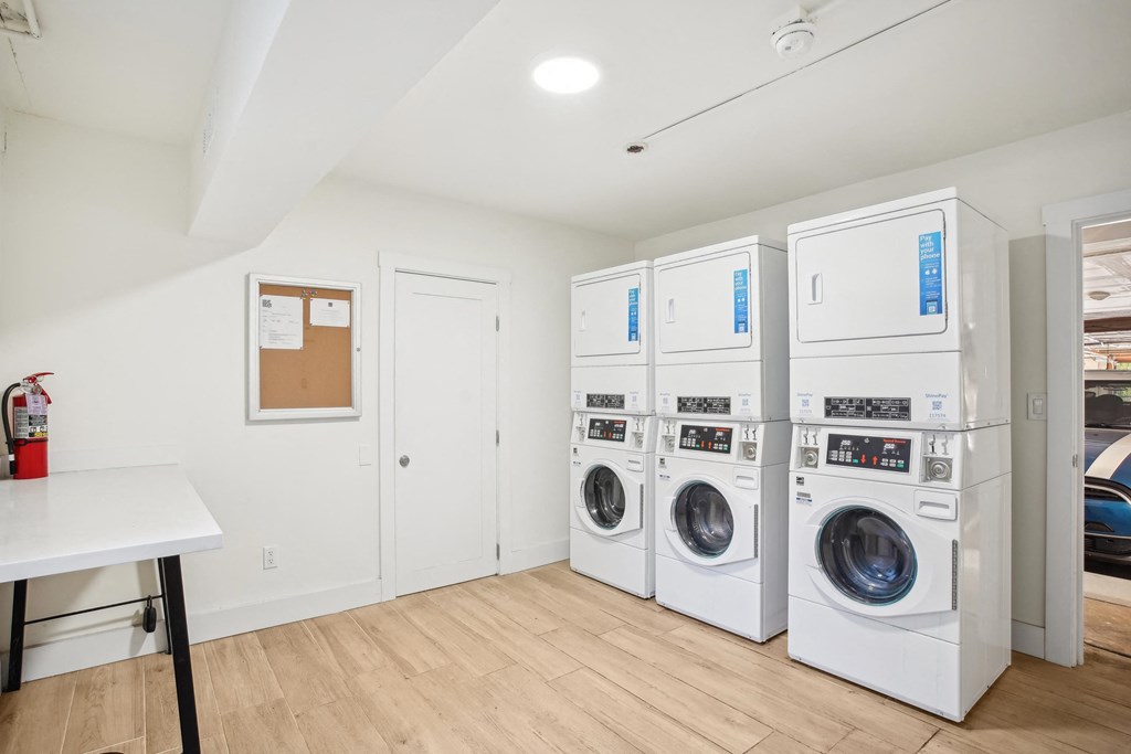 Laundry room with washing machines neatly arranged on a wooden floor