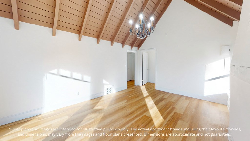 a large living room with white walls and wood floors and a chandelier