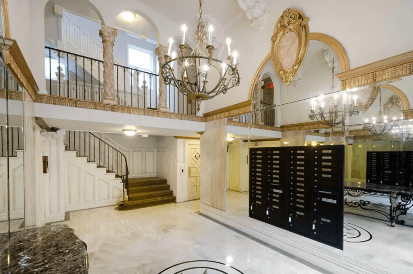 Elegant lobby with a grand staircase, a chandelier, and Victorian-style interior design