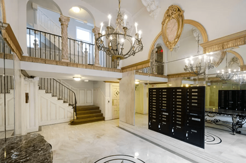 Elegant lobby with a grand staircase, a chandelier, and Victorian-style interior design