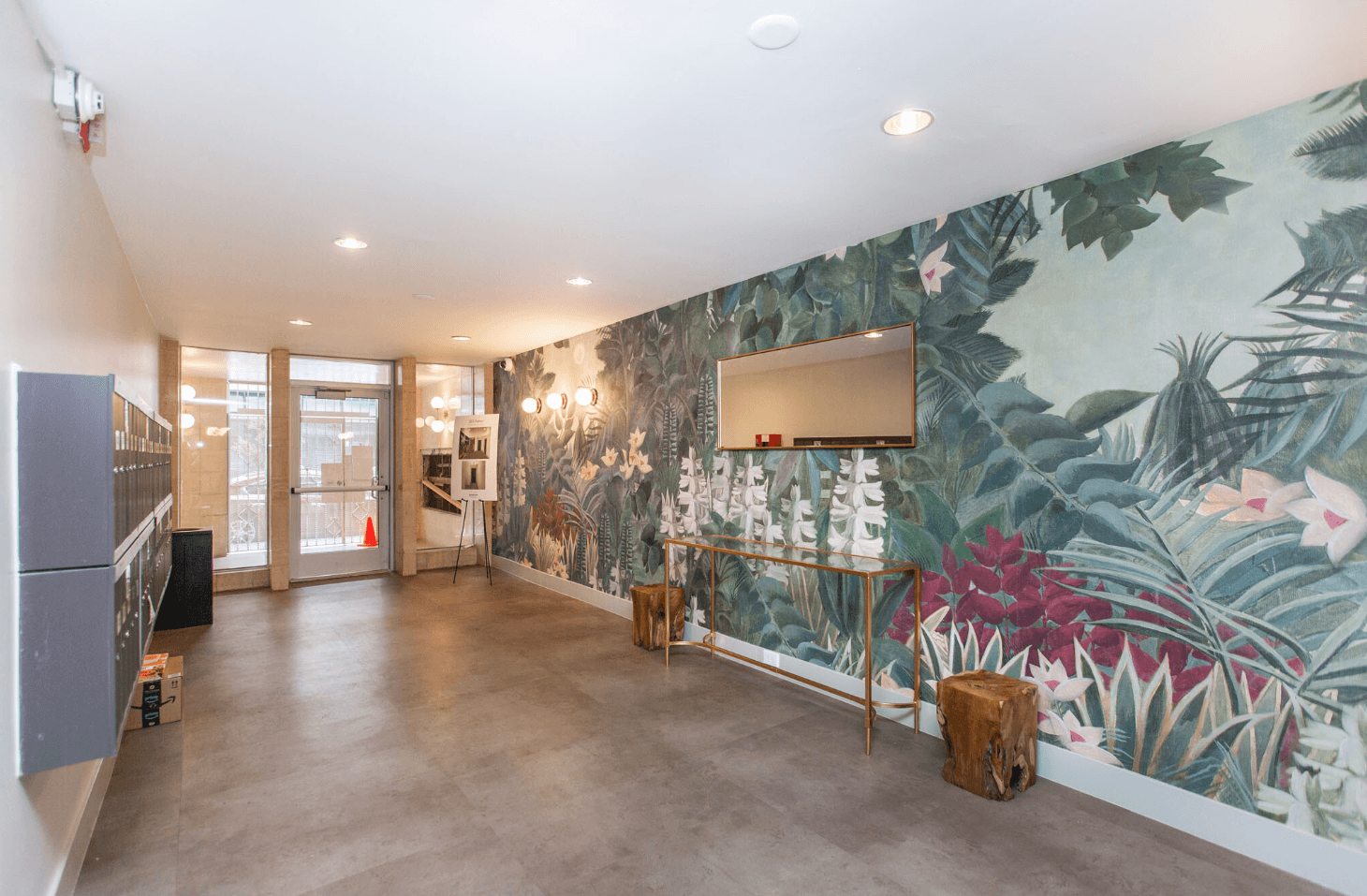 A room with a large mural of tropical plants on the wall.