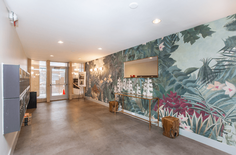 A room with a large mural of tropical plants on the wall.
