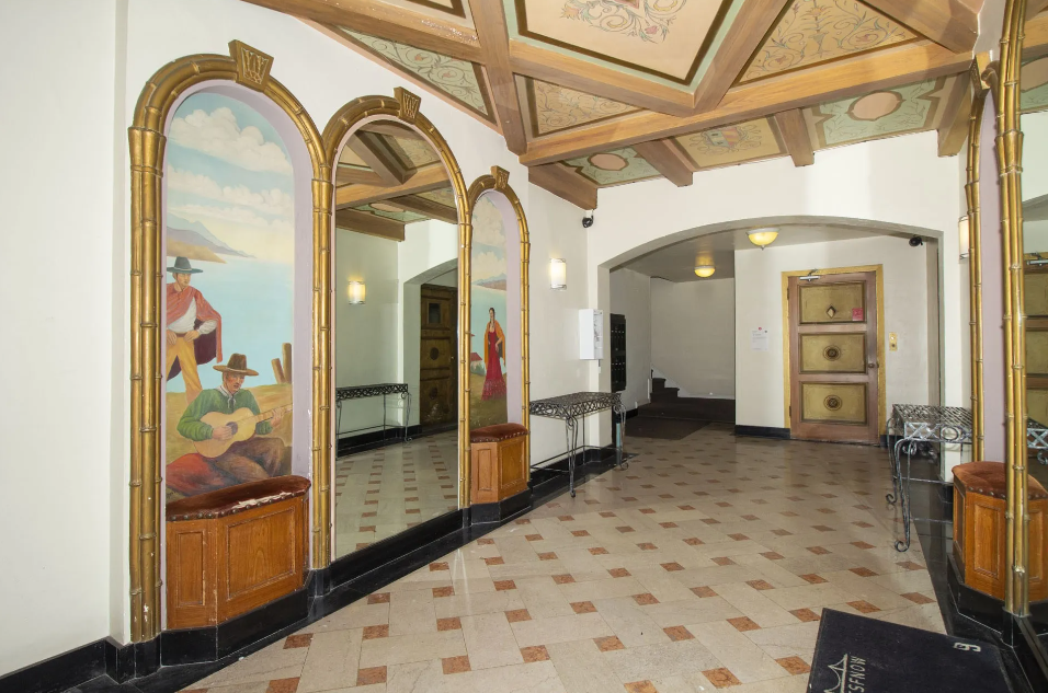 a large hallway with large mirrors and a painting on the wall