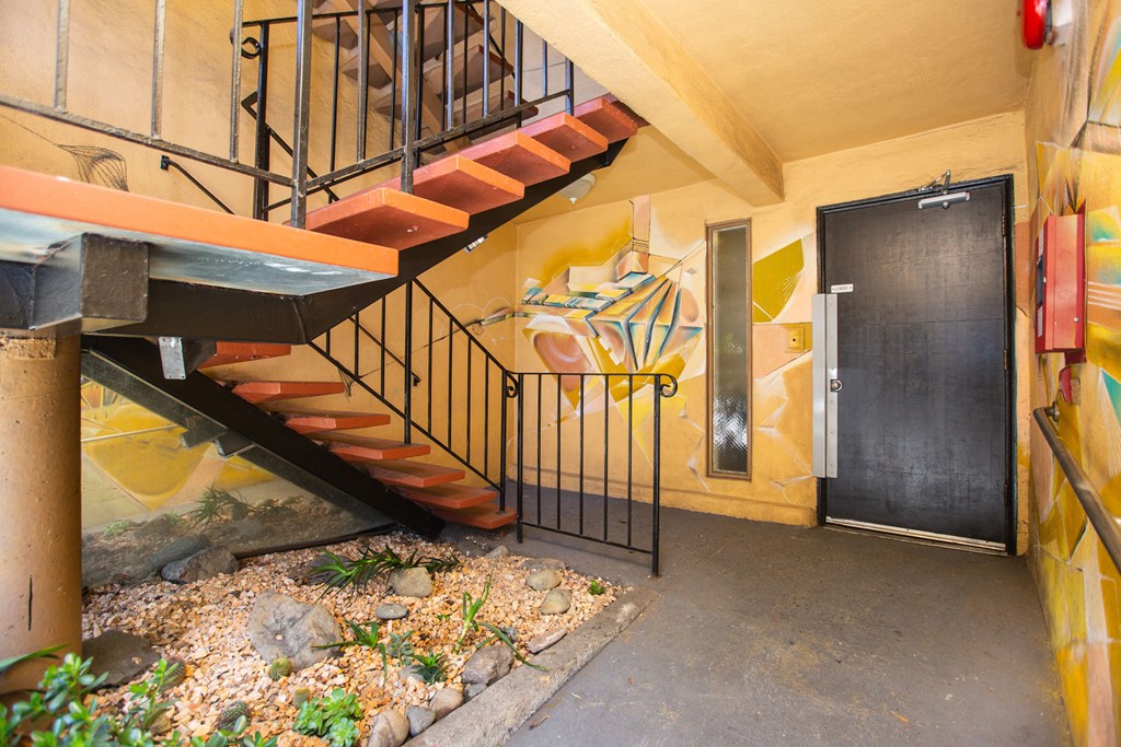 Hallway with a staircase and a small garden with rocks and plants