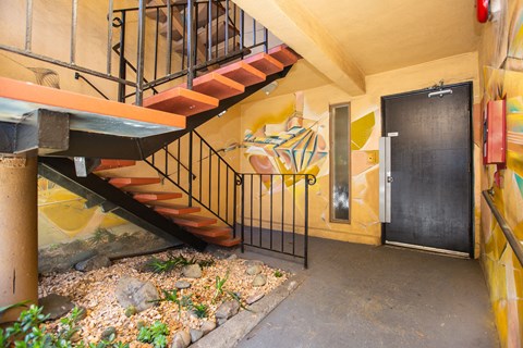 Hallway with a staircase and a small garden with rocks and plants