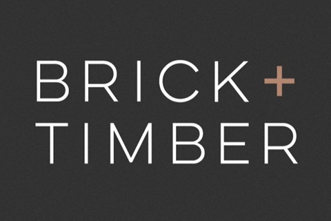 A black background with the words "Brick + Timber" in white and a brown plus sign.