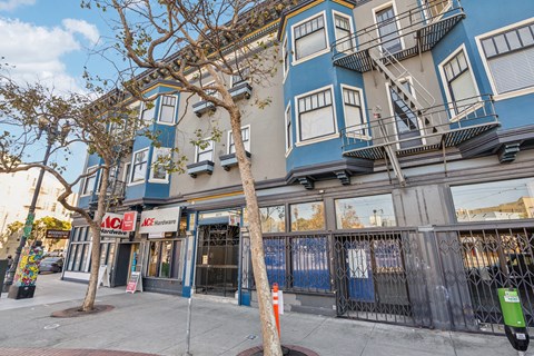 A blue and white building with a tree in front of it.