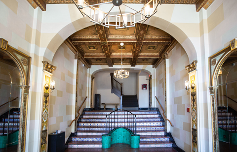 A grand staircase with a chandelier hanging from the ceiling.