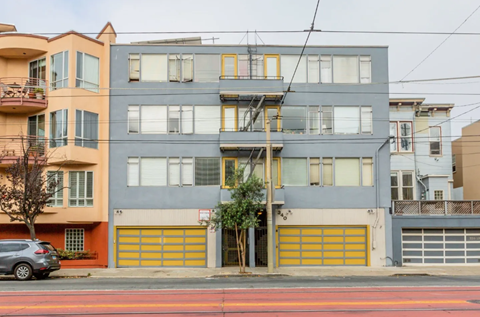 A grey building with a yellow garage door in front.