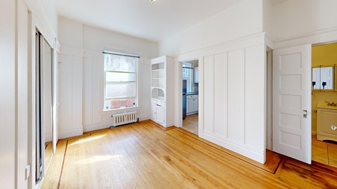 A room with white walls and wooden floors.