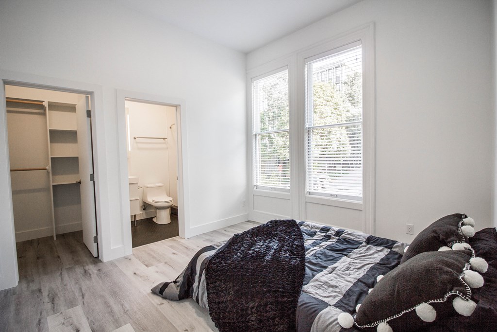 "Bedroom with bed, ensuite bathroom, and a spacious window for abundant natural light."