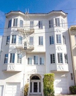a white building with a balcony and a door