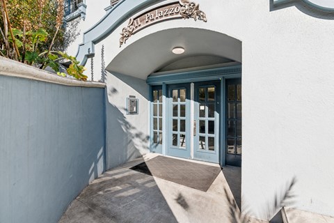 The entrance to a building with a blue door and a sign above it.