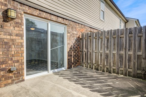 A wooden fence is in front of a house.