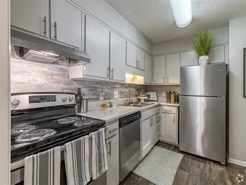 a kitchen with stainless steel appliances and white cabinets at Tucker Square, Stone Mountain