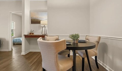 Dining nook with round table and upholstered chairs at Ansley Place Apartments, Louisiana