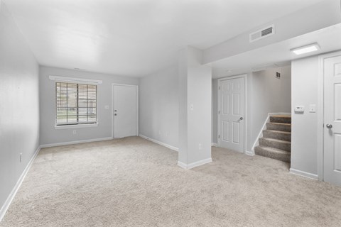 A spacious room with a carpeted floor and a staircase leading to another room. at Eagles Edge Apartments, Indiana