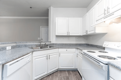 A kitchen with white appliances and cabinets.