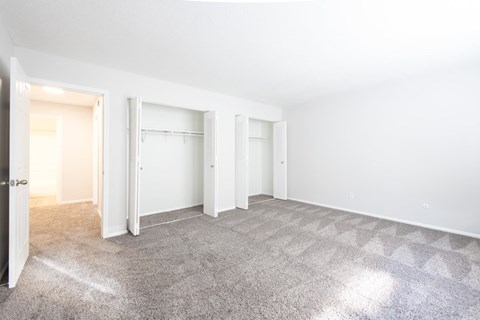 Empty bedroom with dual closets and carpet flooring at Country Lake Estates Apartments, Indiana, 46229