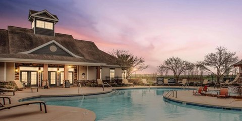 Clubhouse pool area at sunset with lounge chairs at Ansley Place Apartments, Houma, 70360