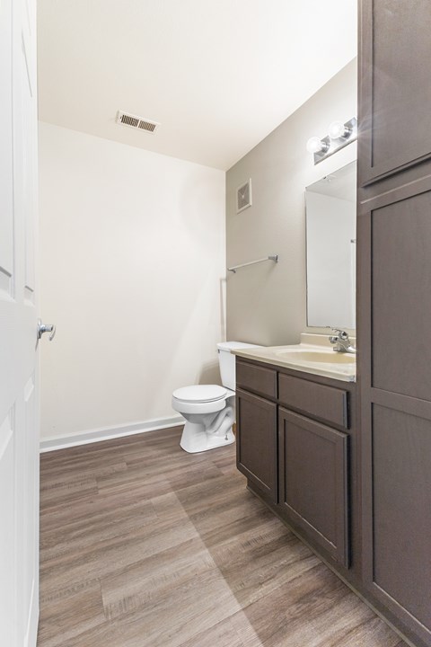 Bathroom with wood style flooring and dark vanity at Northampton Village Apartments, Indianapolis, Indiana