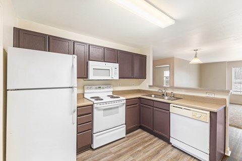 A kitchen with brown cabinets and white appliances.