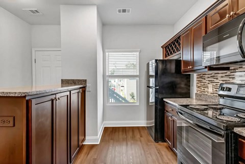 A kitchen with dark wood cabinets and stainless steel appliances.
