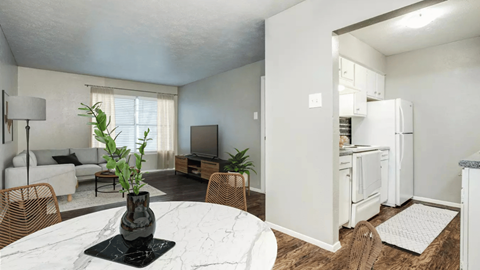 A modern kitchen with a white fridge and a dining table with chairs.