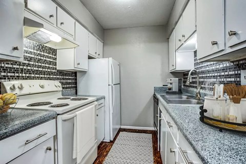 A kitchen with white appliances and cabinets.