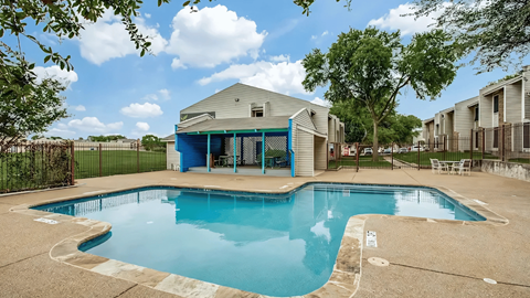 A swimming pool in a residential area with a house in the background.