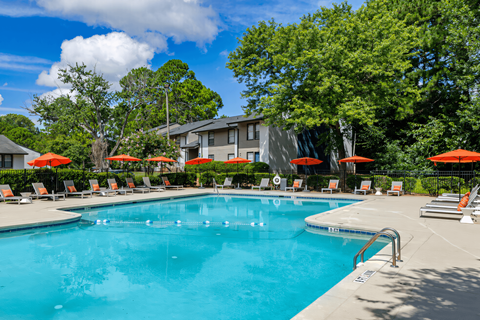 a swimming pool with chairs and umbrellas and a building in the background at Glen Hollow,Decatur, GA, 30034