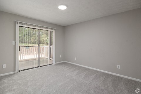 an empty living room with a sliding glass door to a balcony at Glen Hollow, Georgia 30034