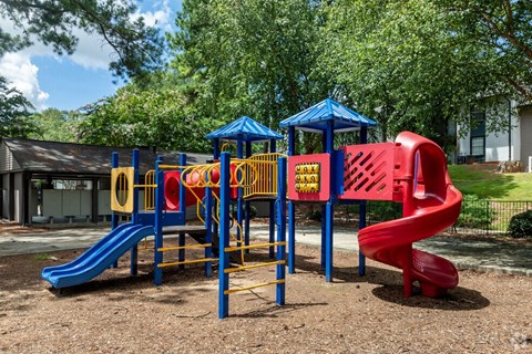 a playground with a swing set and slides at a parkat Glen Hollow, Decatur, Georgia