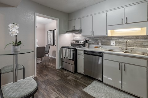 a kitchen with white cabinets and stainless steel appliances and a dining table