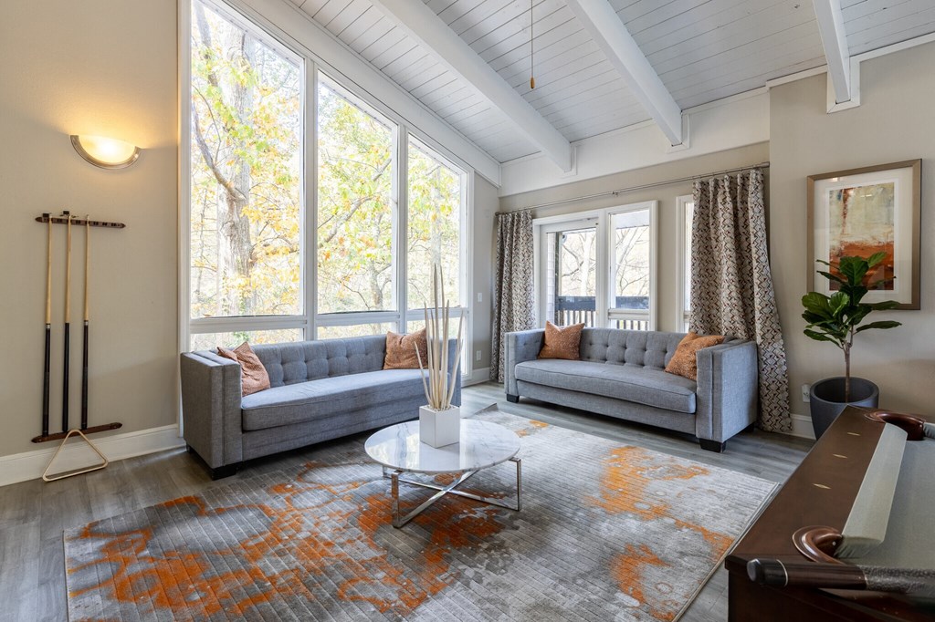 two couches and a table in the clubhouse with large windows at Tucker Square, Stone Mountain, Georgia