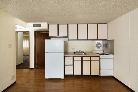 A kitchen with white appliances and brown cabinets.