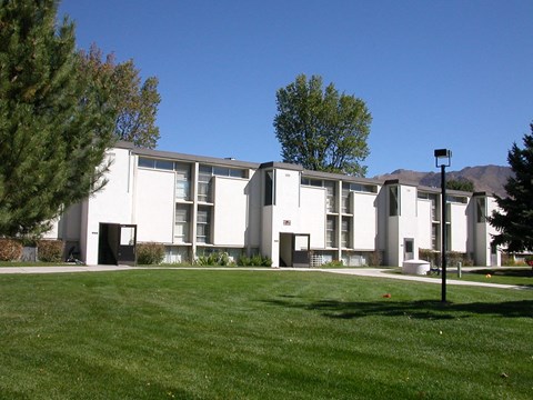 A white building with a green lawn in front.