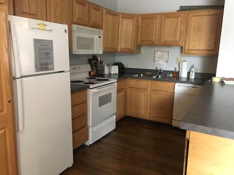 a kitchen with white appliances and wooden cabinets