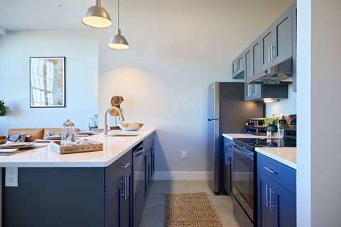 A kitchen with a white counter top and blue cabinets.