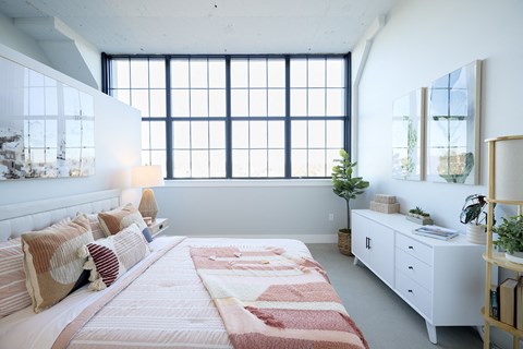 A bedroom with a large bed and a window.