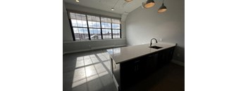 A kitchen with a large window and a countertop.