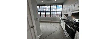 A kitchen with a view of the city through the window.