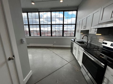 A kitchen with a view of the city through the window.