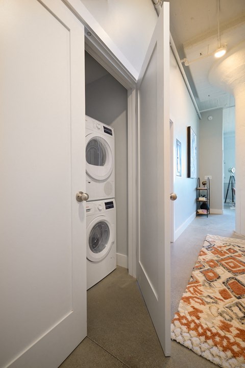 A white washing machine is in a white door.