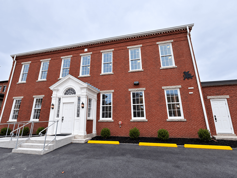 A red brick building with a white door and windows.