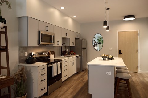 A modern kitchen with white cabinets and a wooden island.