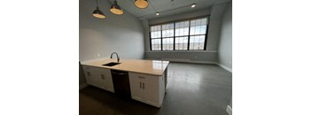 A kitchen with white cabinets and a large window.